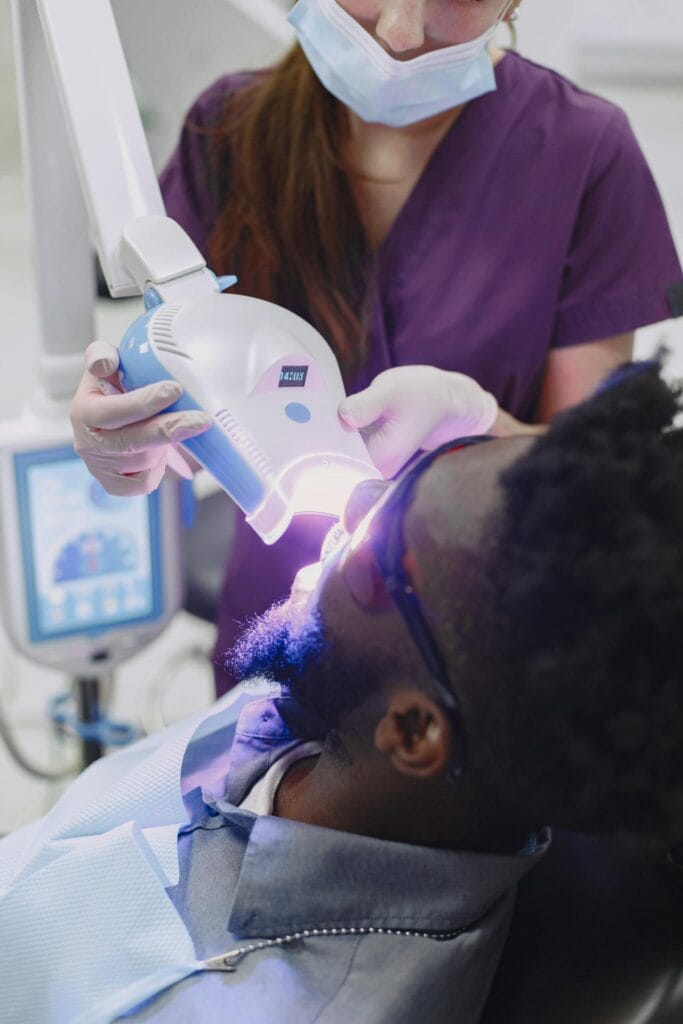 Dentist performing professional teeth whitening with curing light in Beirut clinic